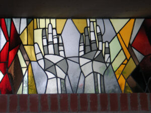 Hände im Fenster der Kapelle